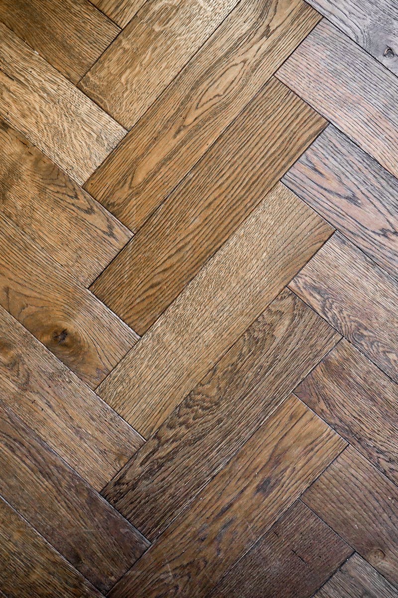 Stylish herringbone parquet floor pattern in warm wood tones, perfect for interior design inspiration.