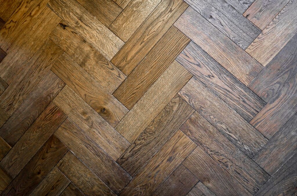 Stylish herringbone parquet floor pattern in warm wood tones, perfect for interior design inspiration.